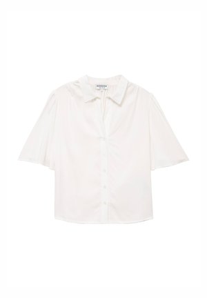 Camicia bianca a maniche corte con collo e bottoni, maniche leggermente svasate, mostrata distesa su uno sfondo bianco.