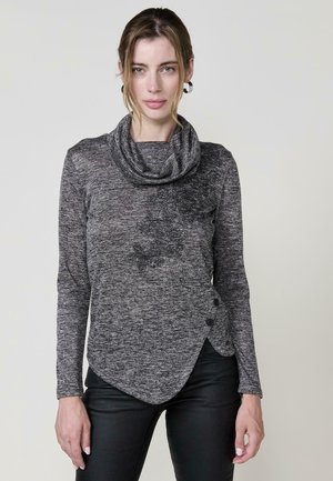 Top de manga larga con cuello cisne en un tejido texturizado gris-negro, que presenta un dobladillo asimétrico y botones decorativos en el lateral.