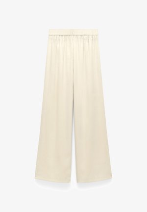 Beige broek met wijde pijpen en elastische tailleband, gemaakt van gladde, lichte stof, afgebeeld tegen een witte achtergrond.