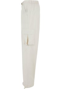 Lys beige cargo bukser med elastisk linning, sidelommer og en lomme på låret med logo broderi. Taperede manchetter.