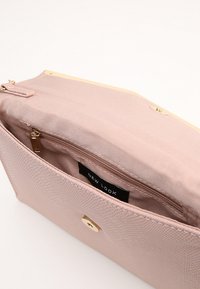 Rosa strukturierte Clutch mit goldenen Hardware, ausgestattet mit einem Reißverschlussfach und einem gefütterten Innenraum. Das Label lautet "NEW LOOK."