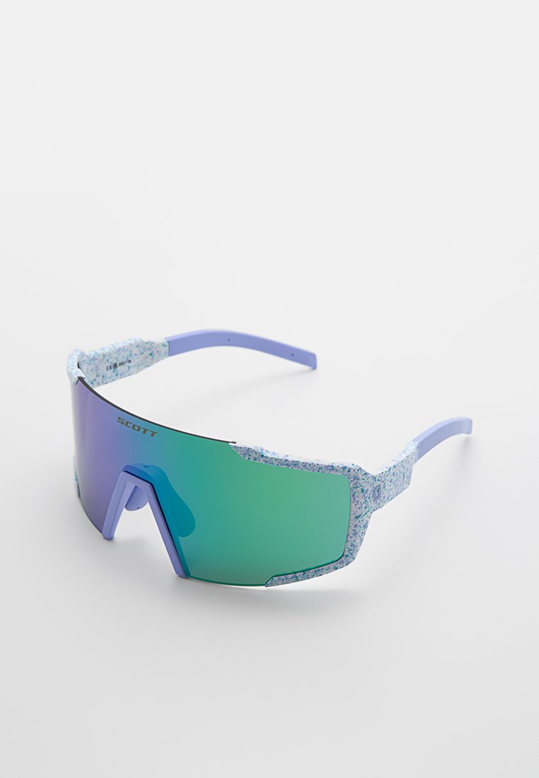 Gafas de sol con lentes grandes de color verde degradado, montura de color púrpura claro y patas texturizadas de color azul con un diseño moteado.