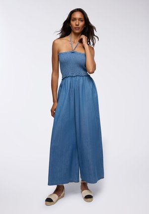Salopette blu senza spalline con corpetto arricciato e pantaloni a gamba larga, realizzata in un morbido tessuto simile al denim. Presenta un collo all'americana e una vita elastica.