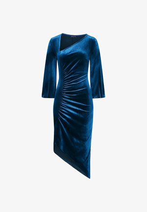 Samtkleid in tiefem Blau, mit langen Ärmeln, asymmetrischem Saum und gerafften Details an der Seite. Glatte Textur, elegante Silhouette.