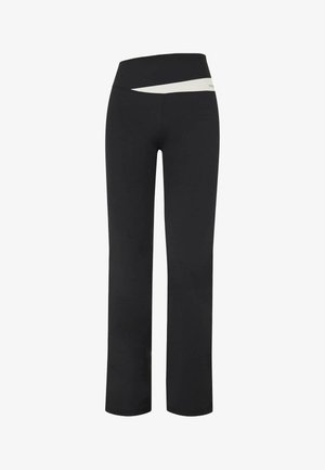 Pantalons de yoga noirs taille haute avec un détail de bande angulaire blanche sur la taille, présentant une silhouette ajustée et des jambes droites.