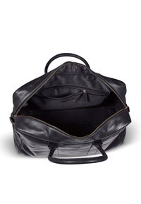 Svart lær duffelbag med en glatt tekstur, glidelås-lukking, to håndtak og interne lommer. Fôret inni.