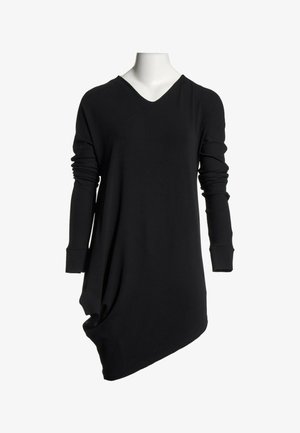 Robe asymétrique noire à manches longues avec col en V et détail froncé sur un côté, présentée sur un buste de mannequin blanc.