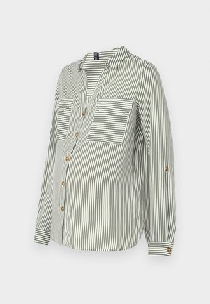 Zaļš un balts svītrots krekls ar pogu, ar V veida kakla izgriezumu, divām krūšu kabatām un sarullētām piedurknēm, kurās ir zelta pogas. Vieglas auduma.