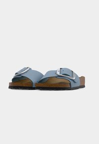 Ανοιχτά σανδάλια ανοιχτής μύτης σε ανοιχτό μπλε χρώμα με ασημένια αγκράφα, πάτο από φελλό και υφασμένη μαύρη ελαστική σόλα, με λείο επάνω σχέδιο.