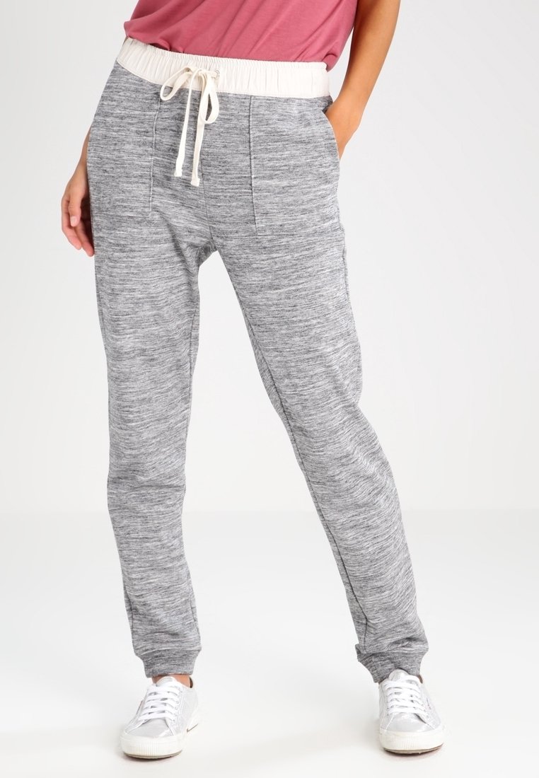 Grå sweatpants med en texturerad mönster, elastisk midja, snörning och sidofickor. Matchat med vita sneakers.