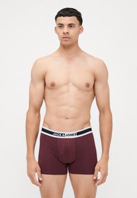 Boxer briefs bordeaux realizzati in tessuto morbido con un elastico in bianco e nero con logo. Presentano una vestibilità aderente e un design con gamba corta.