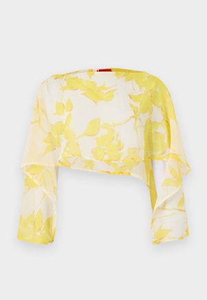Gennemsigtig cropped top i gult blomsterprint. Letvægts, flydende materiale med lange ærmer. Blød tekstur og afslappet fald.