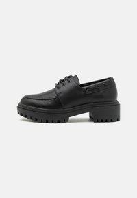 Zwarte leren schoenen met een ronde neus, vetersluiting en chunky rubberen zool met gestructureerde groeven voor grip.