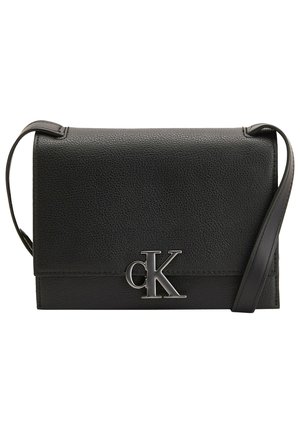 Sac bandoulière en cuir noir avec finition texturée et logo argenté Calvin Klein "cK" sur le rabat avant, avec une fine sangle d'épaule réglable.