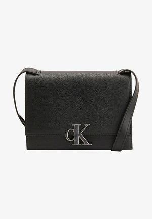 Bolso bandolera de cuero negro con acabado texturizado y logo plateado "cK" de Calvin Klein en la solapa frontal, con una correa de hombro delgada y ajustable.