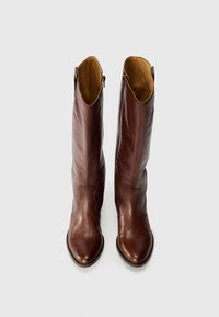 Brown leather knee-high boots with a smooth finish, featuring side zippers and decorative stitching, displayed against a white background.