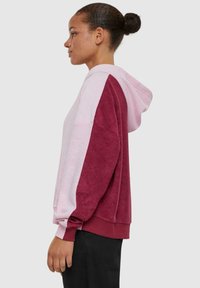 Hoodie in lichtroze en bordeaux. Heeft een relaxte pasvorm met een color-block ontwerp en ribgebreide manchetten. Zachte textuur, casual stijl.