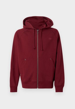 Dunkelroter Kapuzenpullover mit Reißverschluss, Kordelzug, Fronttaschen, gerippten Bündchen und Saum sowie einem dezenten Logo auf der linken Brust.