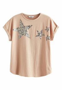 Camiseta rosa claro de manga corta con diseños de estrellas de lentejuelas plateadas de diferentes tamaños en el pecho.