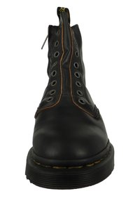 Svart läderankelhalkboots med siddragkedja, ikonisk snörning fram, cirkulära metallöglor och gula sömmar på sulan. Texturerad yta.