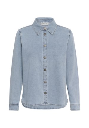 Chemise en denim bleu clair à manches longues avec col pointu et boutons-pression métalliques à l'avant, ourlet légèrement arrondi et détails de couture visibles.