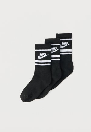 Juego de tres pares de calcetines de algodón negros, con un logo blanco de Nike y dos rayas horizontales blancas en la parte superior. Textura suave, longitud hasta la mitad de la pantorrilla.