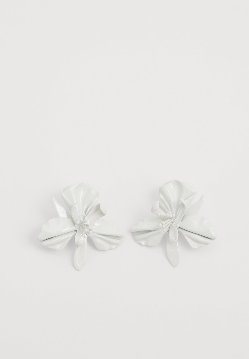 Brincos florais de cerâmica branca com pétalas e caules detalhados, apresentando um acabamento brilhante e um design simétrico.