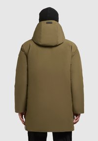Olivu zaļa izolēta parka ar kapuci, plašu apkakli, garām piedurknēm, taisnu griezumu un gludu, matētu apdari. Iespējams, minimāls aprīkojums.