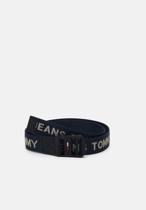 Laivastonsininen kangasvyö mustalla soljella ja beigeillä "Tommy Jeans" -tekstillä, jossa soljessa pieni punaisen, valkoisen ja sinisen lipun logo.