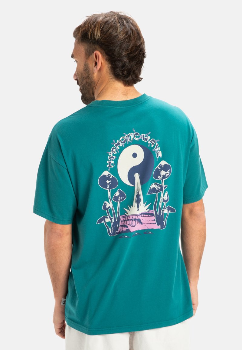 Camiseta de algodón en color teal con un diseño gráfico en la parte trasera que presenta setas, un símbolo del yin-yang y el texto "Hypnotic Wave" en blanco y rosa.