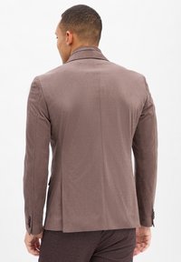 Brauner Wildleder-Blazer mit slim Fit, Reverskragen und einfacher Sch vent. Verfügt über eine glatte Textur und geknöpfte Manschetten, von hinten gezeigt.