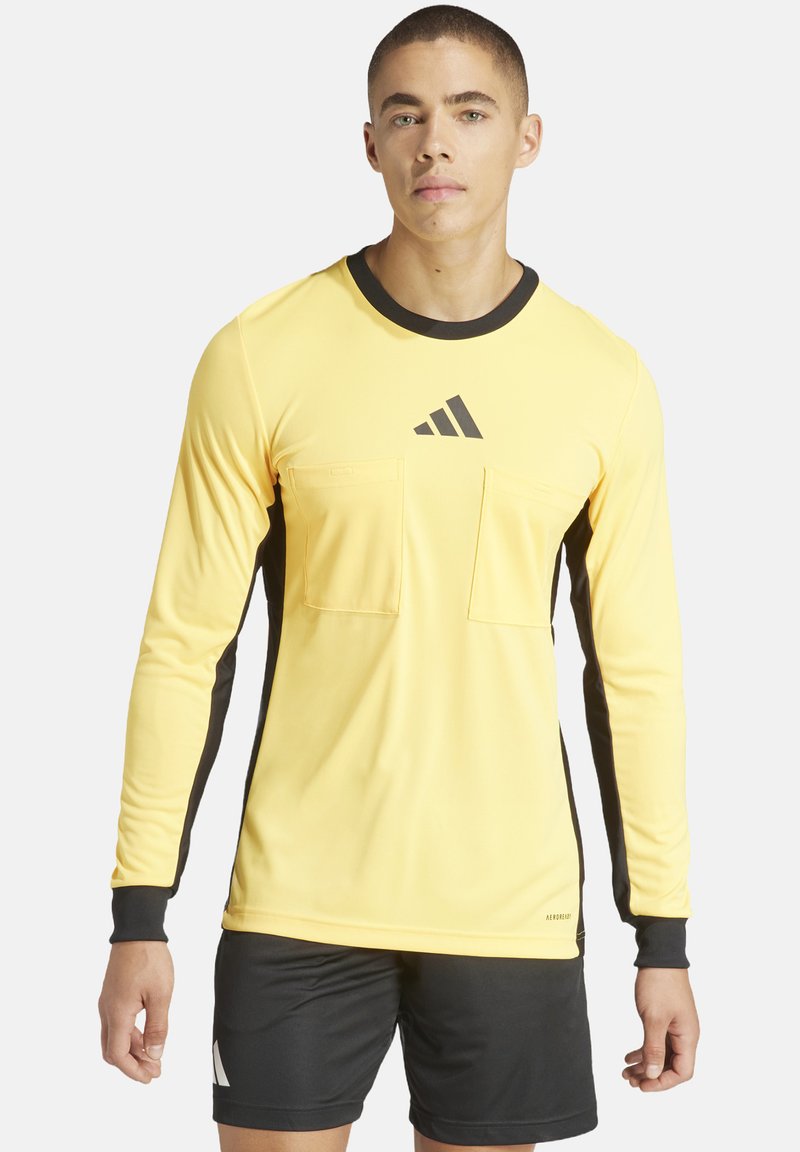 Gelbes langärmliges Sportshirt mit schwarzem Kragen und seitlichen Einsätzen, ausgestattet mit zwei Fronttaschen und einem Adidas-Logo auf der Brust.