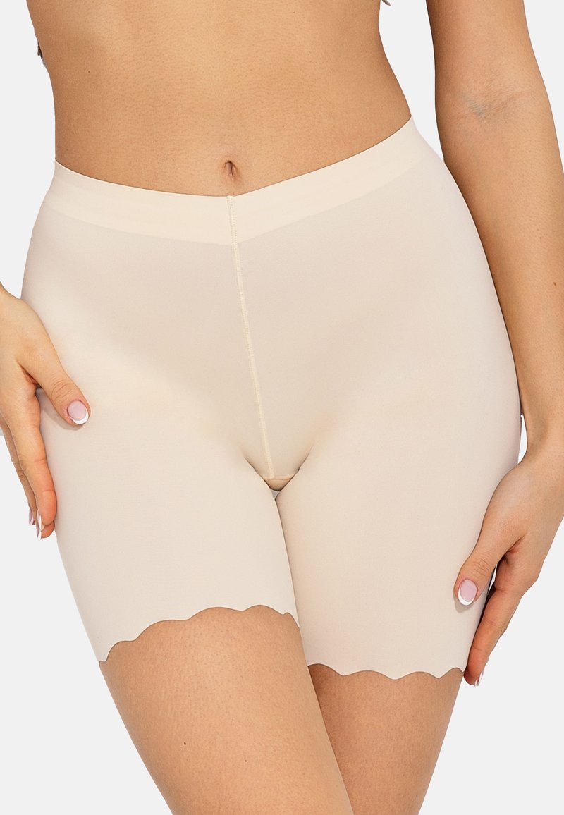 Beige corrigerende shorts met een gladde textuur, hoge taille en golvende zoom. Ontworpen voor een strakke pasvorm, die ondersteuning en bedekking biedt.