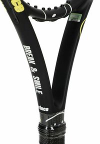 Raqueta de tenis negra con acentos amarillos, que presenta un mango texturizado y un diseño de cuello abierto. El texto dice "ROMPE Y SONRÍE" en blanco.