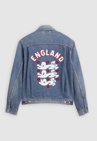 Τζιν μπουφάν με το κείμενο «ENGLAND» πάνω από τρεις λευκούς λιοντάρια και κόκκινα λουλούδια κεντημένα στην πλάτη.