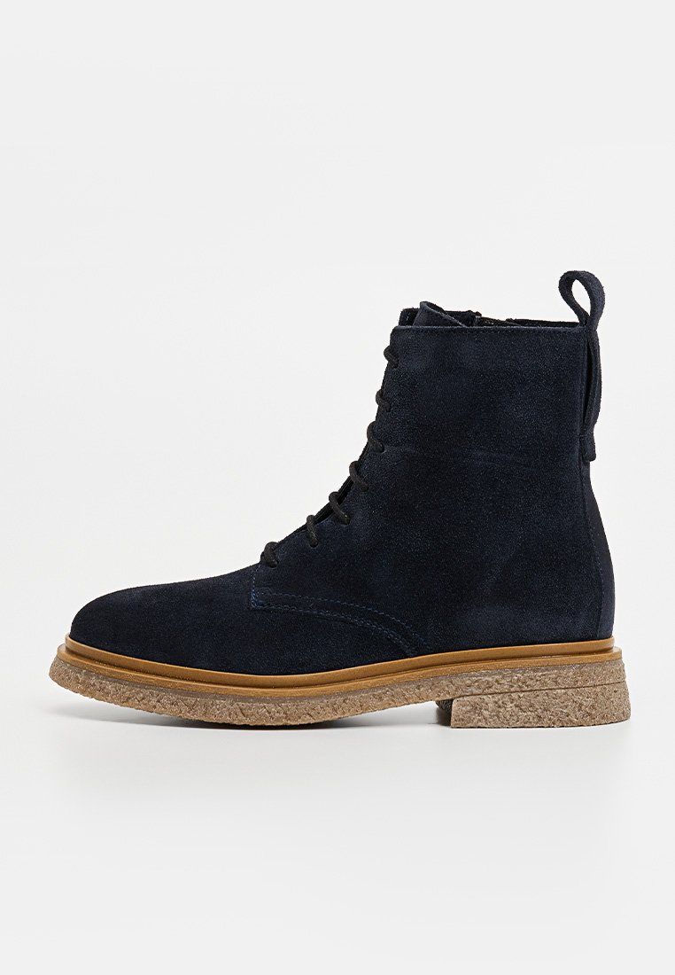 Marineblaue Wildleder-Stiefeletten mit strukturiertem Oberfläche, runder Zehenpartie, Schnürung vorne und Korksohle. Mit einer Schlaufe an der Rückseite für einfaches Anziehen.