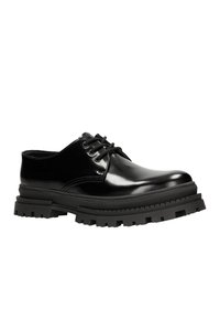 Scarpe in pelle nera con lacci, dalla finitura lucida, suola in gomma nera spessa e battistrada testurizzato per una maggiore aderenza. Nessun accento o motivo visibile.