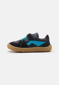 Scarpa di colore blu scuro e nera con una cinghia in velcro, caratterizzata da un'accensione azzurra e una suola in gomma color beige con scanalature texturizzate.