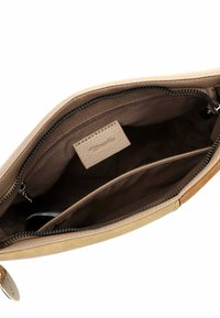 Beige leather handbag with a zip closure, featuring a spacious brown fabric interior and multiple compartments for organization.