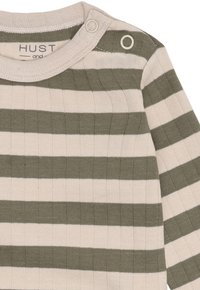 Langärmliges, geripptes Babyshirt mit beigen und olivgrünen horizontalen Streifen sowie zwei Druckknöpfen an der Schulter.