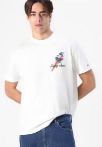 Hvid bomulds-t-shirt med et farverigt isvaffel-grafik og "Tommy Jeans" tekst foran; korte ærmer og afslappet pasform.
