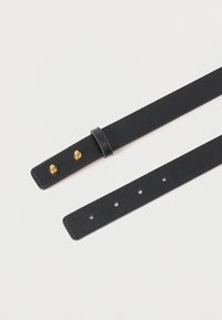 Μαύρο δερμάτινο λουράκι με χρυσές μεταλλικές λεπτομέρειες, λεία υφή, πολλαπλές τρύπες ρύθμισης και ασφαλές κούμπωμα στο ένα άκρο.