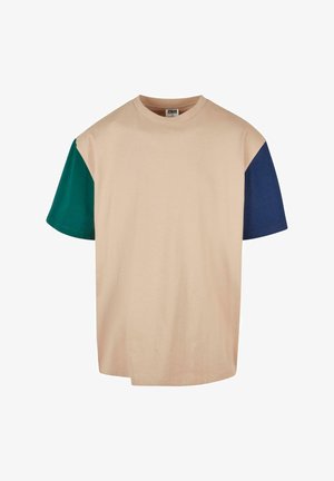 Bež kratki rukav majica s zelenim i tamnoplavim rukavima. Meka pamučna tkanina s okruglim izrezom i opuštenim krojem.