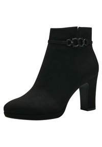 Botas de tornozelo pretas em camurça, com biqueira arredondada e um salto alto em bloco. Uma faixa de destaque com detalhes em metal circular à volta do tornozelo.