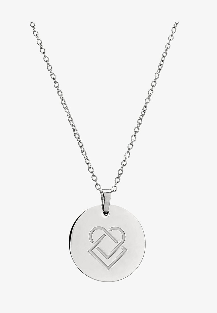 Collier pendentif circulaire en argent avec un motif géométrique en forme de cœur découpé, suspendu à une chaîne.
