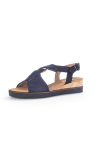 Marineblauwe sandalen met een suede-achtige afwerking, kruisband ontwerp, kurken wedge hak en een gespsluiting. Textuur rubberen zool voor grip.