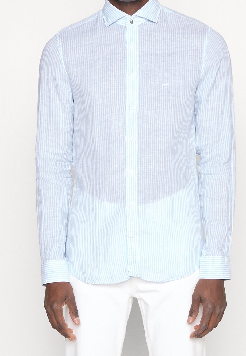Ljusblå randig knappen-up skjorta gjord av andningsbart material, med klassisk krage och långa ärmar. Accentuerad med en liten logotyp på bröstet.