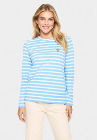 Blauw en witte gestreepte langetermijnshirt met een ronde hals en een klein rood strikembleem op de borst. Katoenen stof met een gladde textuur.