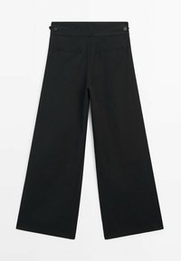 Pantalon noir à jambes larges avec poches passepoilées à l'arrière et pattes de taille réglables avec boutons, présenté à plat sur fond blanc.