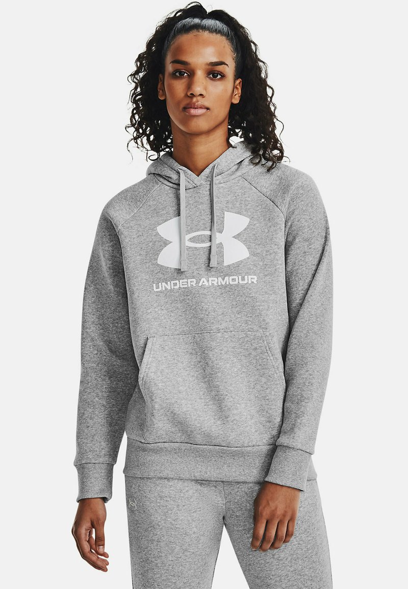 Szara bluza z kapturem wykonana z miękkiego materiału, z dużym białym logo Under Armour oraz kieszenią z przodu. Rękawy raglanowe i ściągacze. 